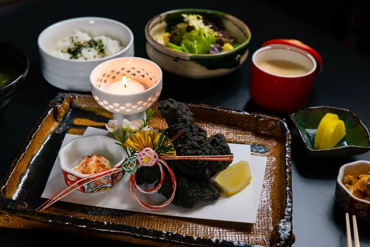 A New Year tray of small dishes set out with a candle
