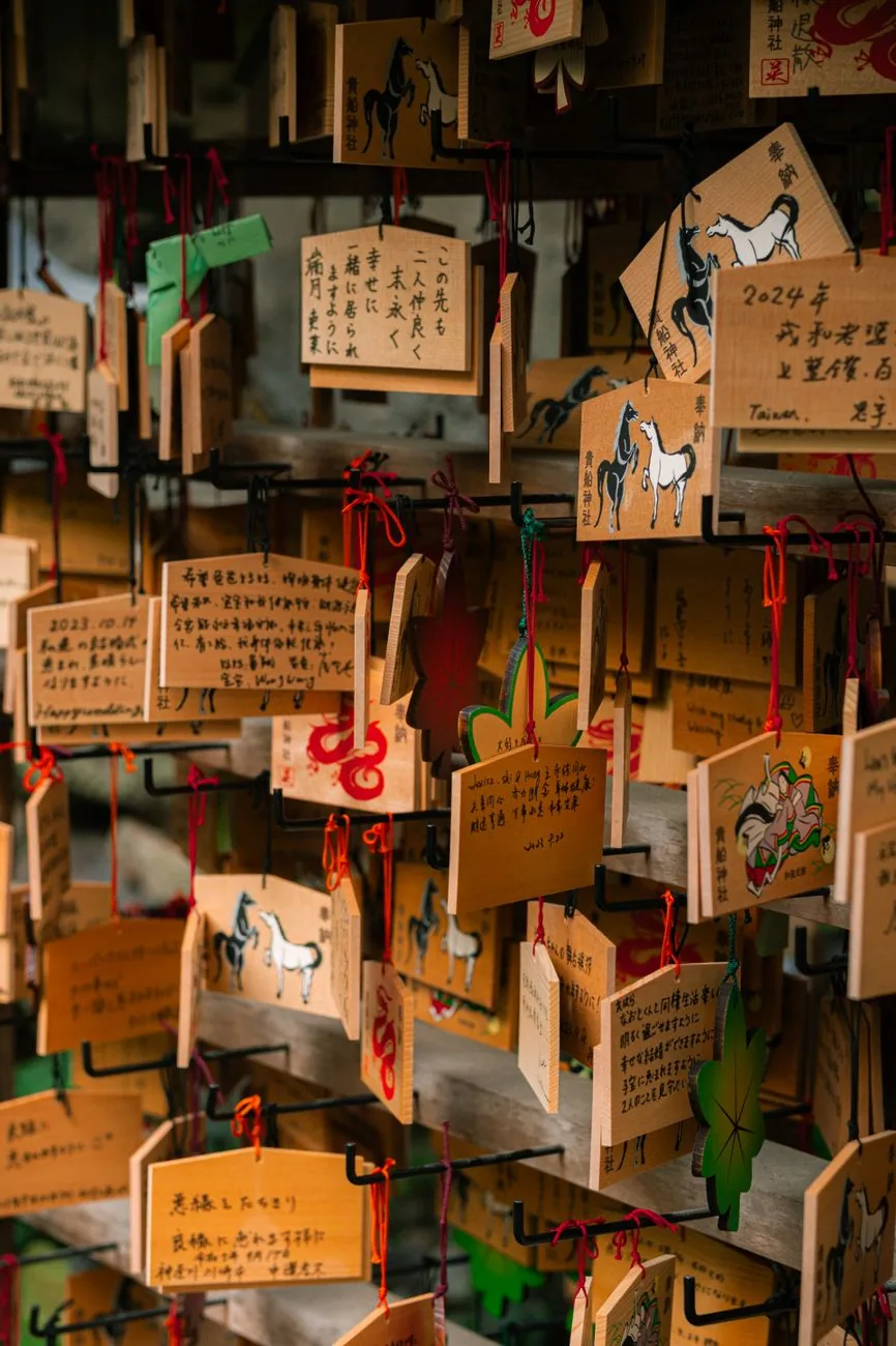 Wooden ema plaques with handwritten wishes at a shrine